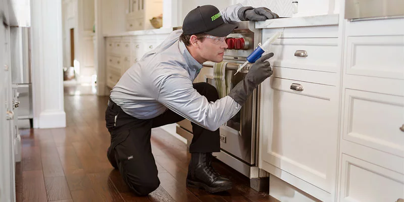 Termnix pest tech working in kitchen