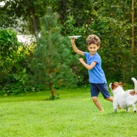 kid playing outside with dog