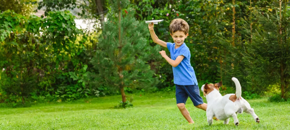 kid playing outside with dog